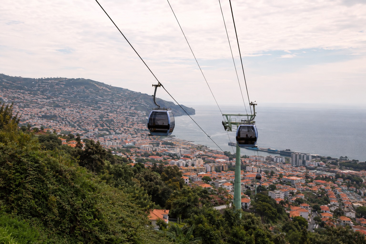 Gondeln der Seilbahn auf dem Weg hinauf nach Monte, unten Funchal und das Meer